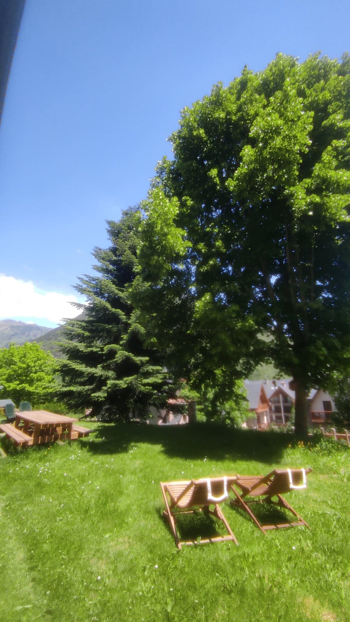 Dos hamacas de madera sobre el césped verde del jardín privado de Casa Lola Pirene en Vielha.