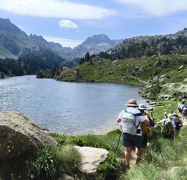 Grupo caminando por sendero bordeando un lago en alojamiento para 12 personas en Val d Aran